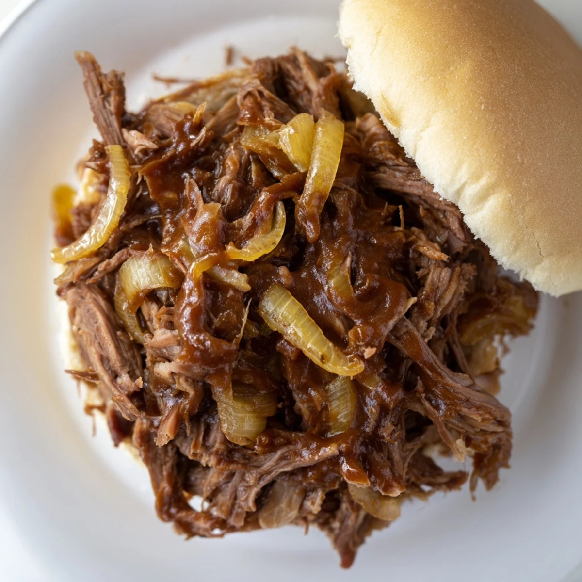 Shredded beef mixture in a slow cooker pot, showing juicy texture for delicious Slow Cooker Pulled Beef Sandwiches ready to serve.