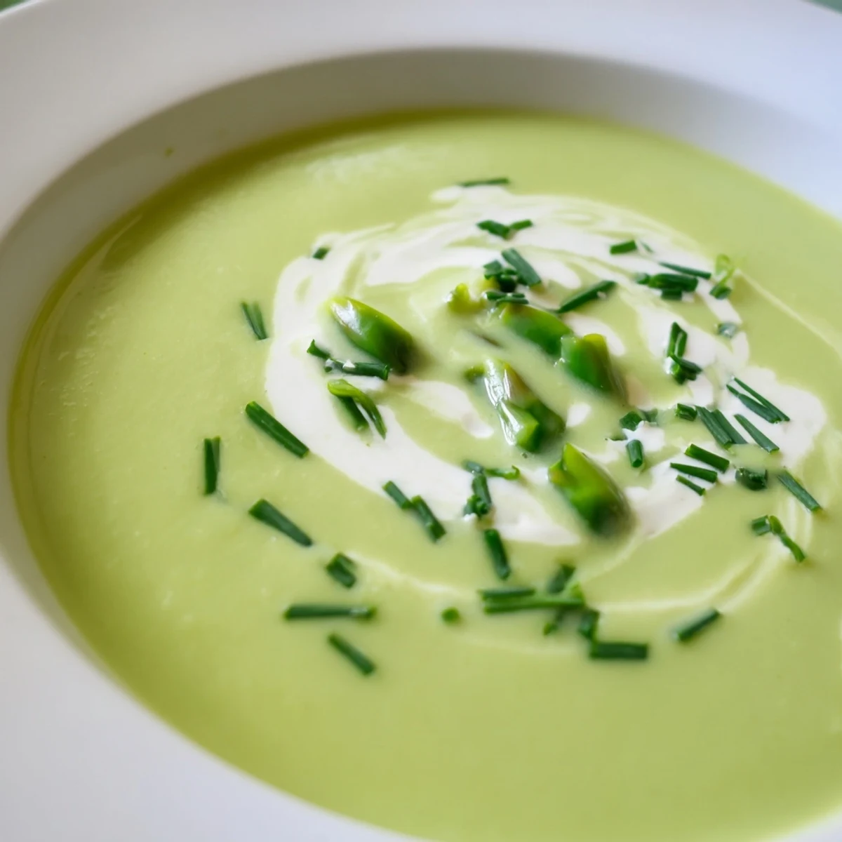 Close-up of hot Creamy Asparagus Soup with Lemon, highlighting bright green puree texture and lemon zest garnish for a light starter.