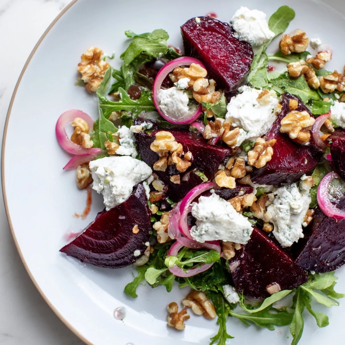 Serving suggestion for Roasted Beet Salad with Goat Cheese on a rustic table with wine glass and golden light