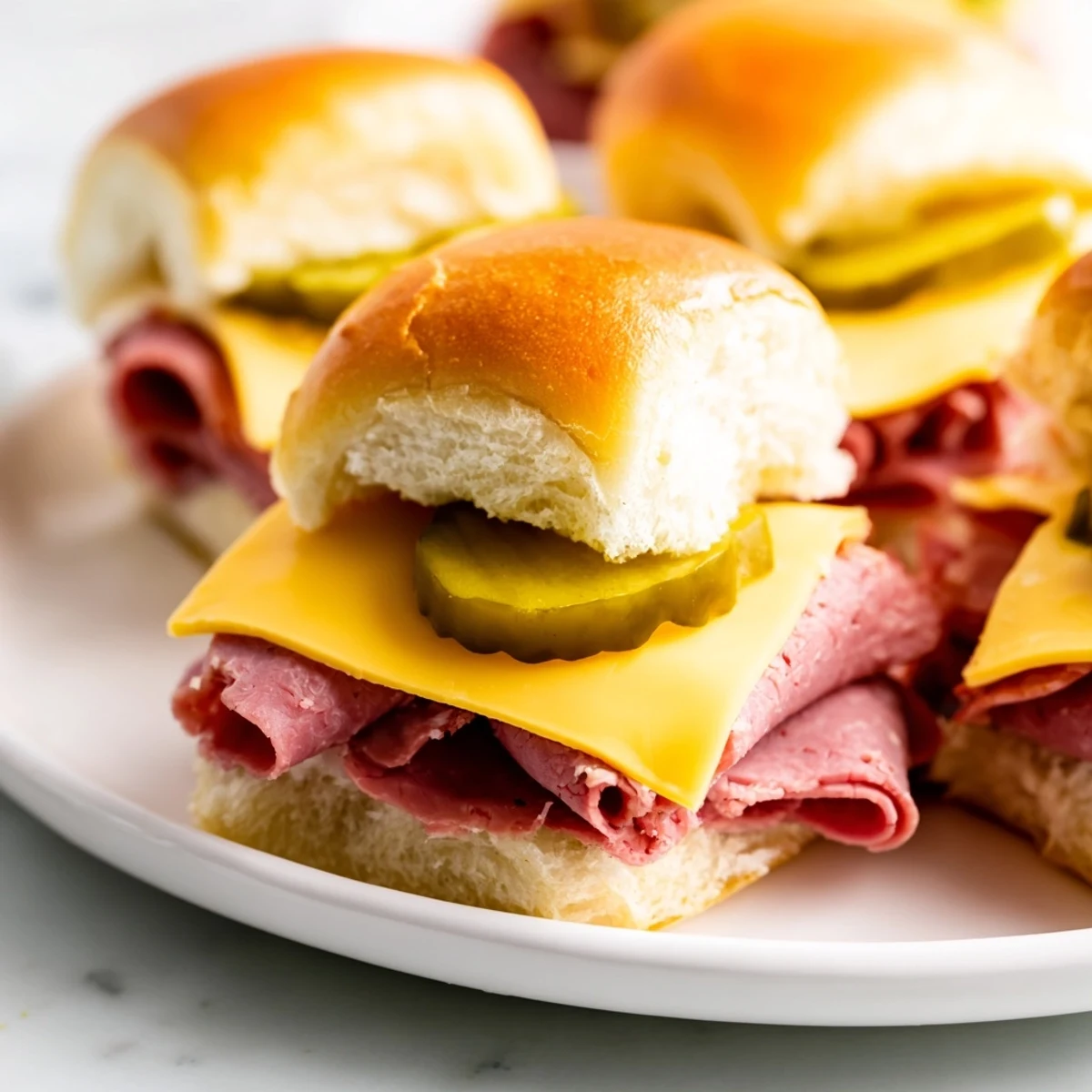 Golden buttery Corned Beef Sliders with garlic poppy seed topping, layered with savory corned beef and cheese for a hearty snack.