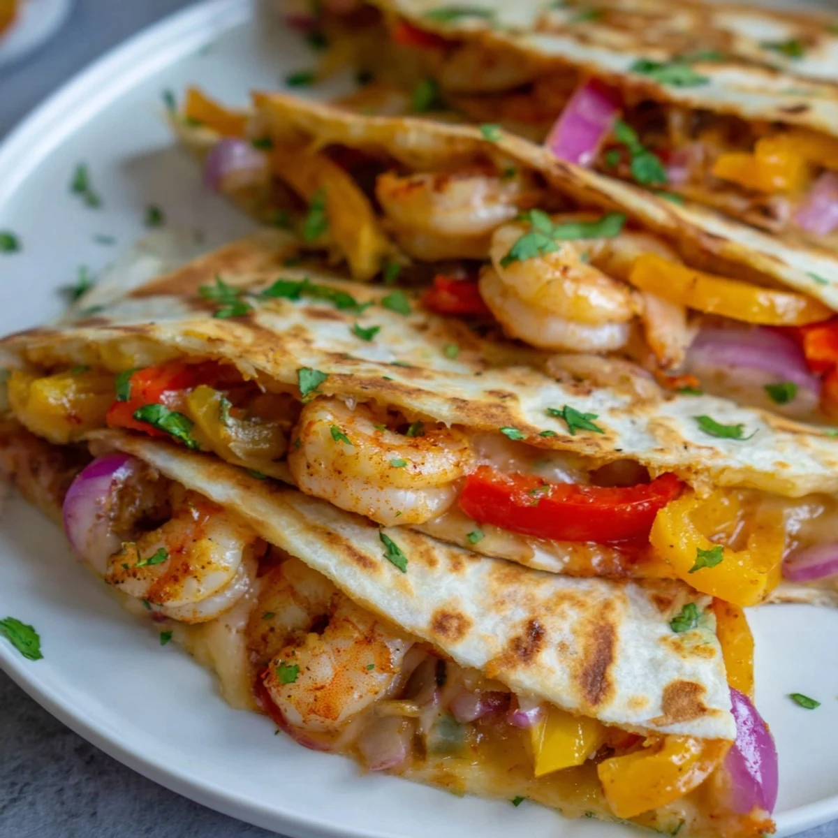 Freshly baked Shrimp Fajita Sheet Pan Quesadillas cut into wedges, revealing a filling of juicy shrimp, sautéed onions, and peppers with cilantro garnish.