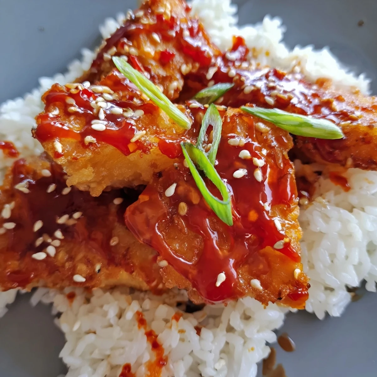 Fluffy white rice topped with golden, crispy sweet & spicy cod strips and a vibrant chili-garlic drizzle.