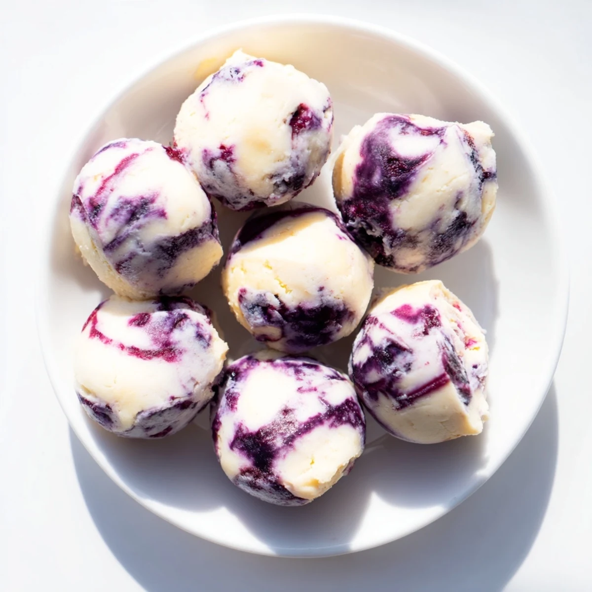 A close-up of Blueberry Cheesecake Protein Bites on a rustic wooden board, with fresh blueberries and a drizzle of honey nearby.