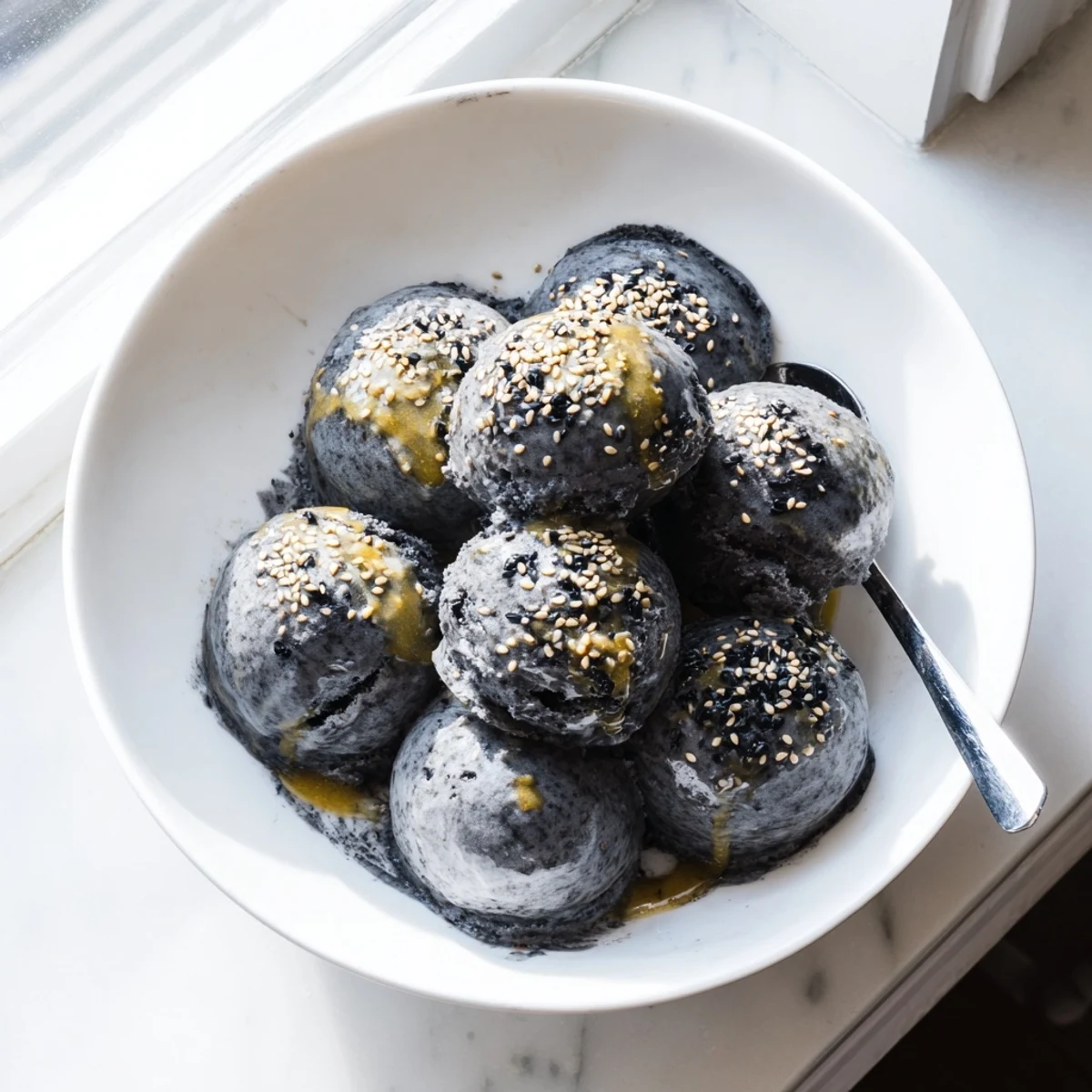 Rich and nutty Toasted Black Sesame Ice Cream in a dessert cup with a fresh spoon.