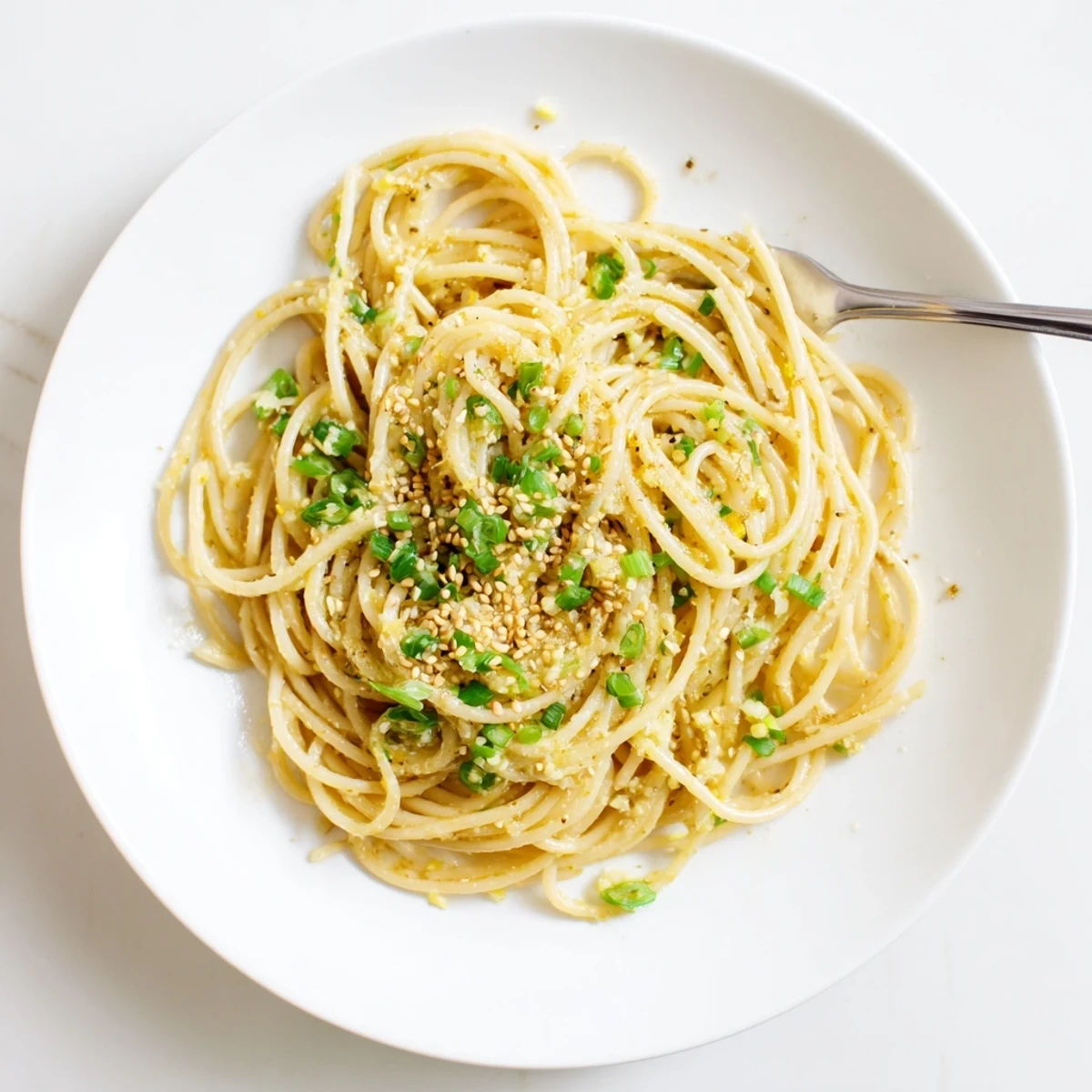 Steaming garlic noodles tossed in a glossy butter sauce with fresh scallions and sesame seeds.