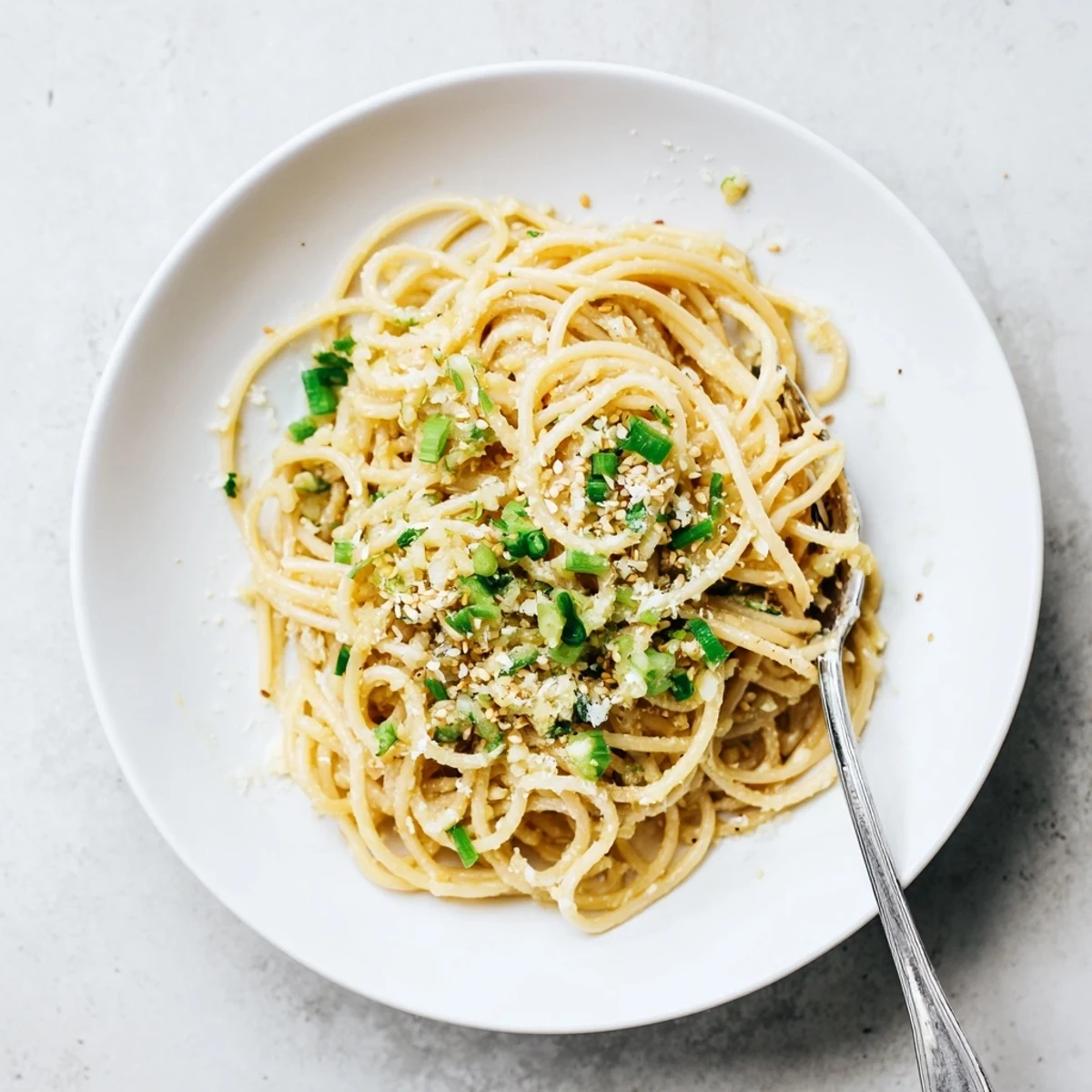 Fork-tender garlic noodles garnished with Parmesan, ready for a savory vegetarian dinner plate.