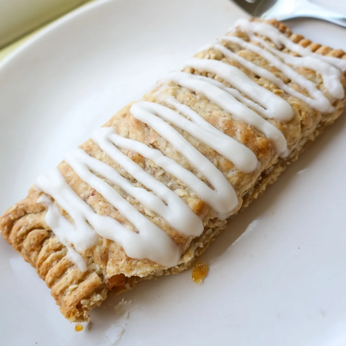 A close-up view shows the flaky pastry of Protein Pop Tarts filled with vibrant red jam, presented on a rustic kitchen counter.