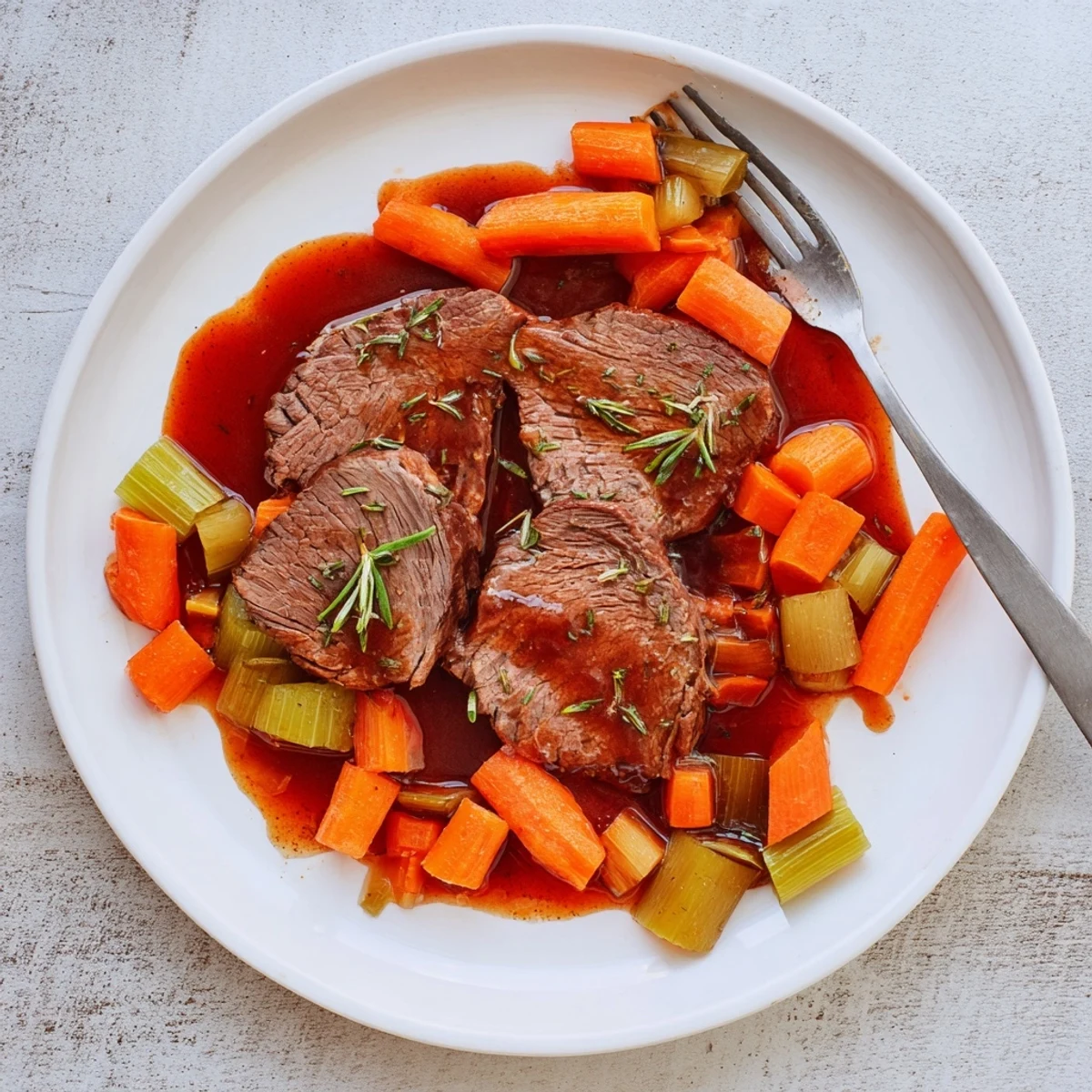 Fork-tender red grape juice braised chuck roast served with carrots and onions