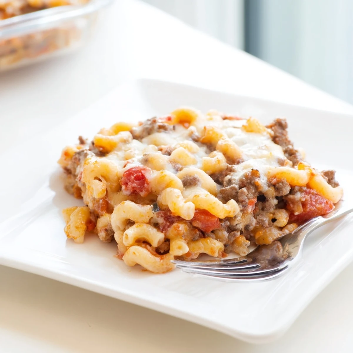 Comforting pasta bake featuring tender elbow macaroni in a tomato beef sauce with golden Parmesan crust