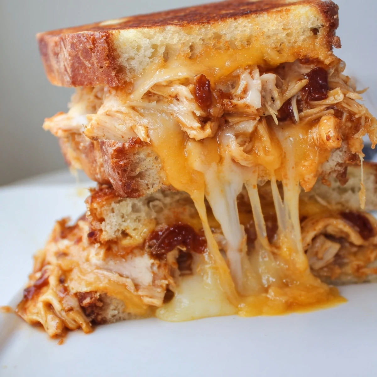 Golden BBQ chicken grilled cheese sandwich with melted cheddar and mozzarella on crispy sourdough bread