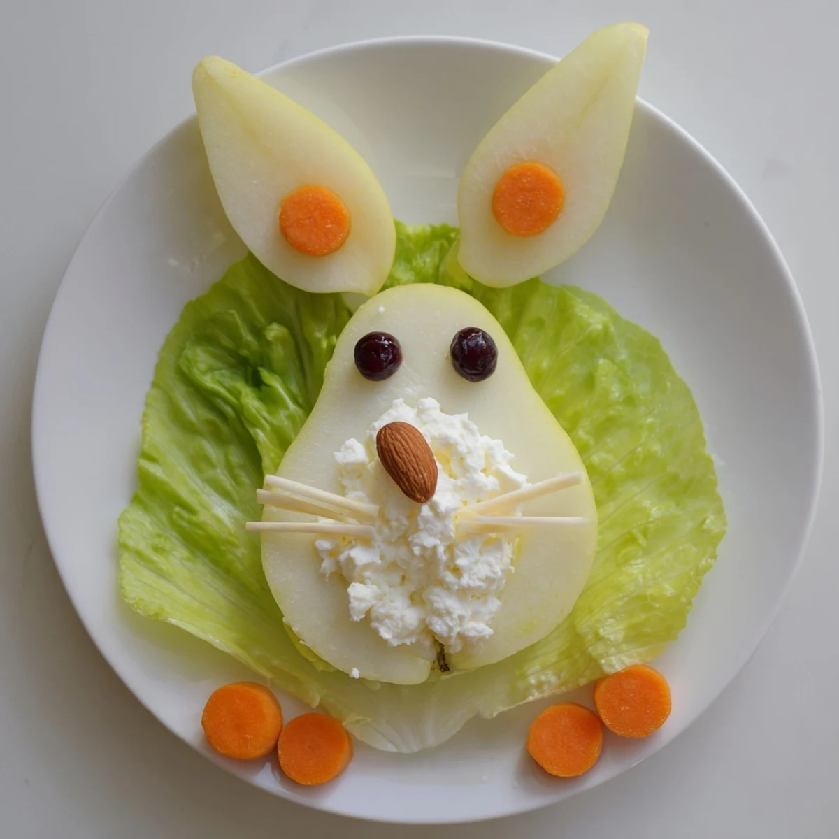 Pear bunny salad featuring cottage cheese tails and adorable fruit decorations on green lettuce leaves