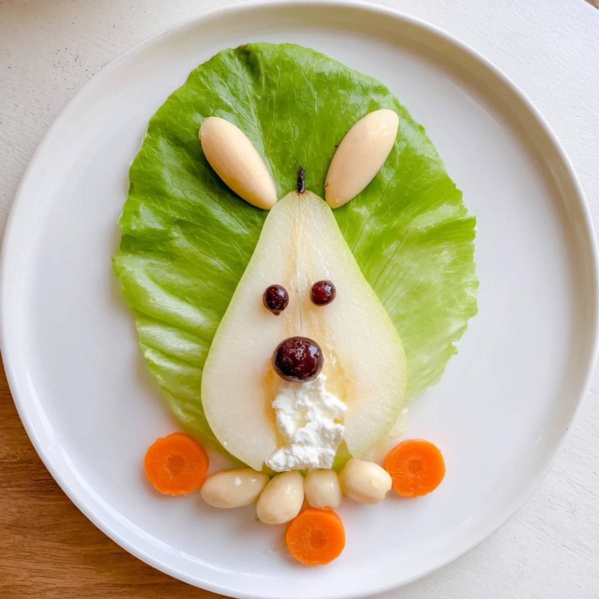 Whimsical pear bunny salad with carrot whiskers, almond ears, and cherry noses arranged on plates