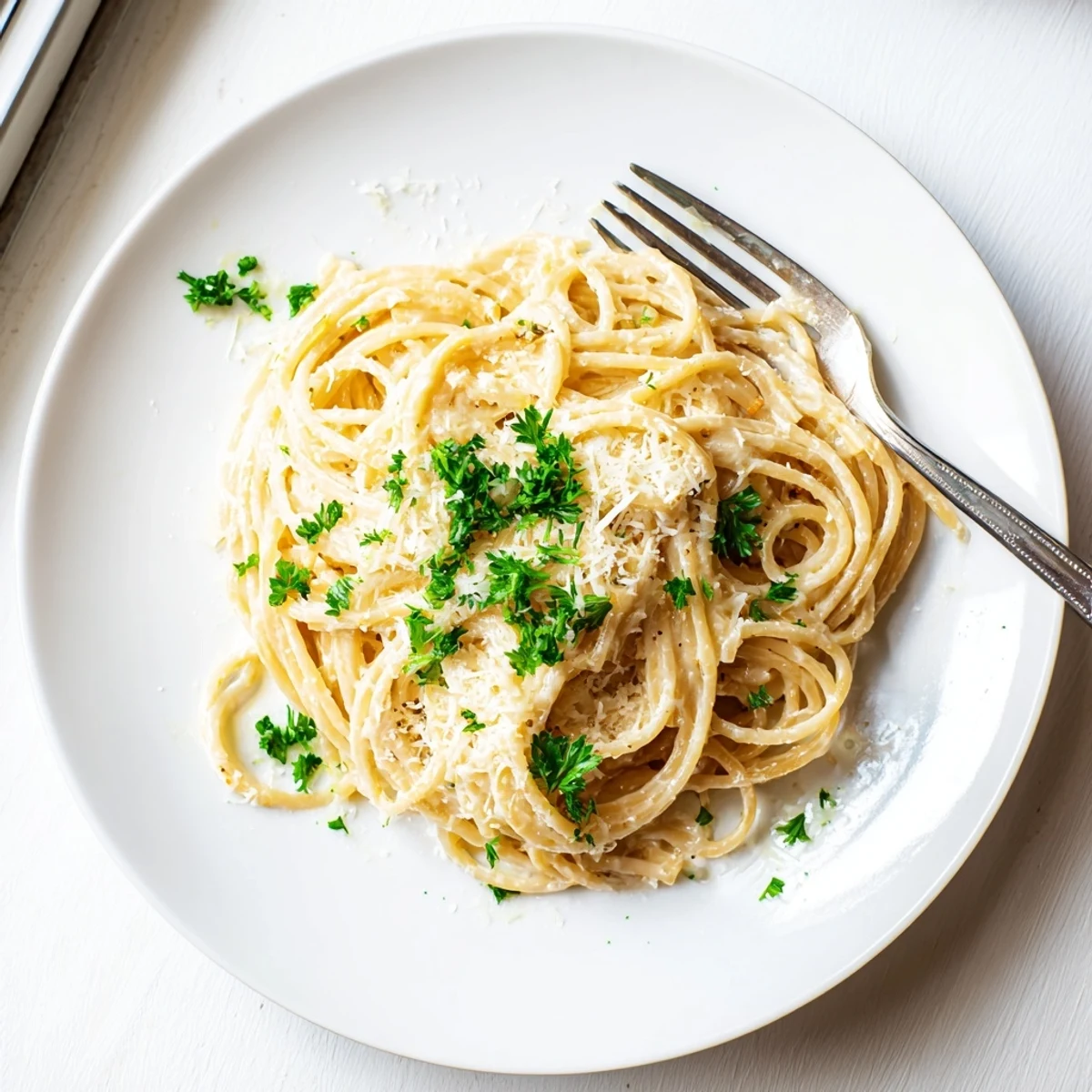 Creamy garlic parmesan spaghetti tossed in rich melted cheese sauce with fresh parsley garnish