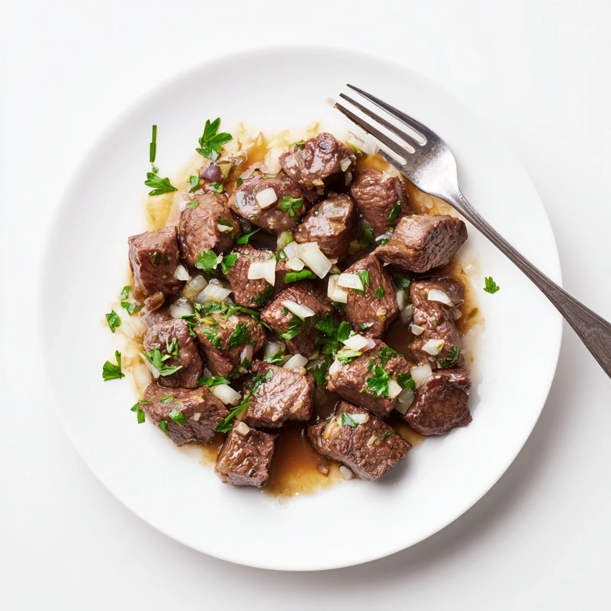 Golden seared crockpot steak bites in savory beef broth with melted butter and onions