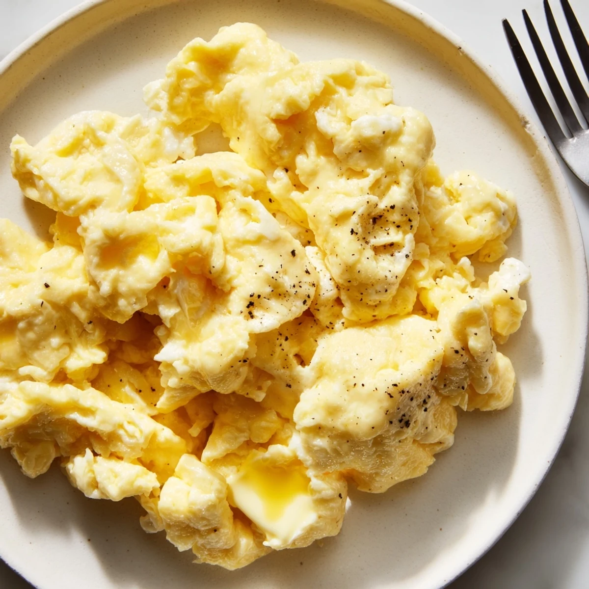 Rich scrambled eggs gently folded into tender curds alongside crispy buttered toast for breakfast