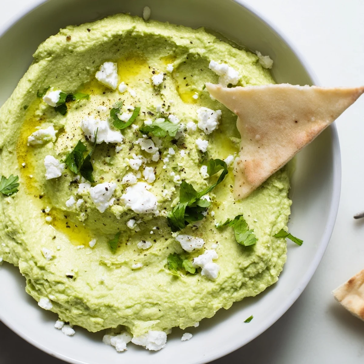 A spoonful of Creamy Avocado Feta Dip served with warm pita.