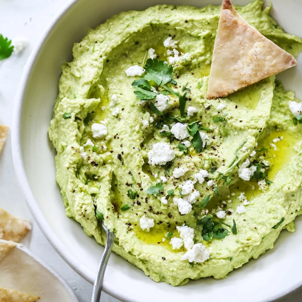 Creamy Avocado Feta Dip in bowl, silky green texture and feta crumbles.