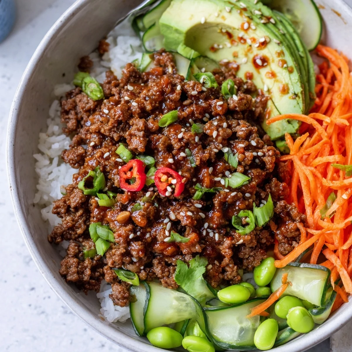 Close up of Viral Ground Beef Hot Honey Bowl with crunchy cucumber and sesame