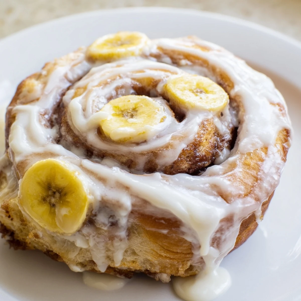 Freshly baked banana cinnamon rolls swirled with cinnamon and topped with sweet cream cheese frosting
