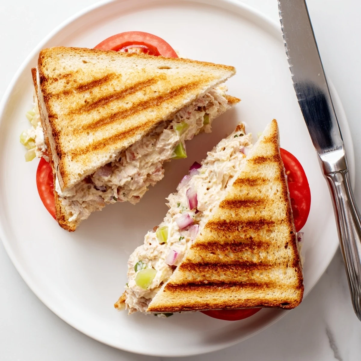 Hot open-faced tuna melt sandwich featuring crispy golden bread and bubbly melted cheese topping