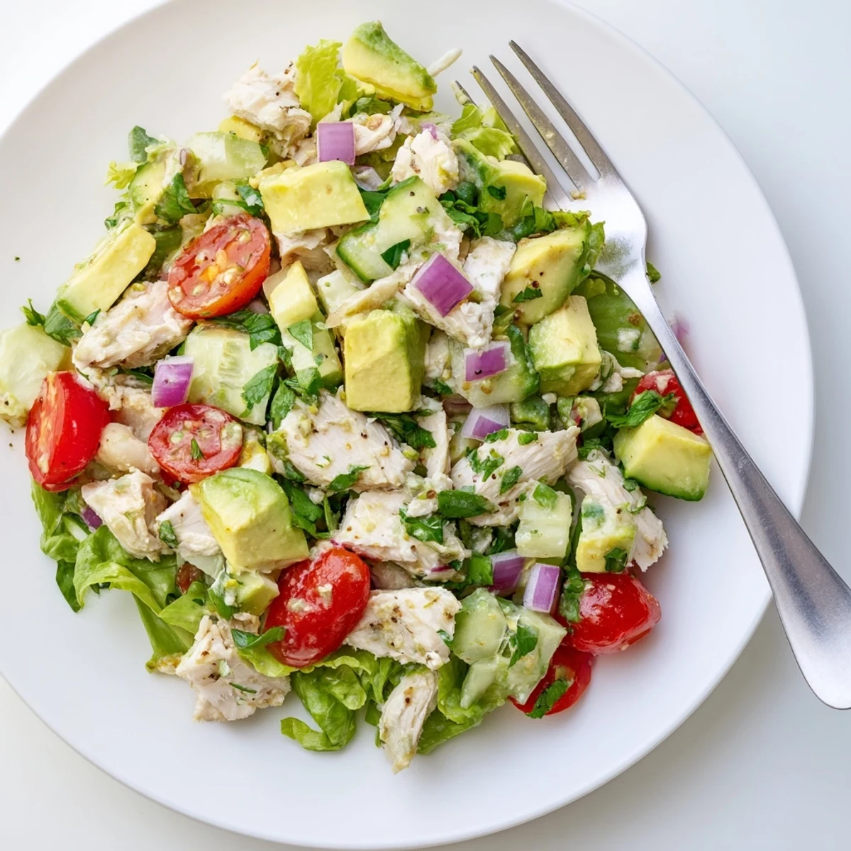 Creamy Avocado Chicken Salad on mixed greens with lime-dressed cherry tomatoes