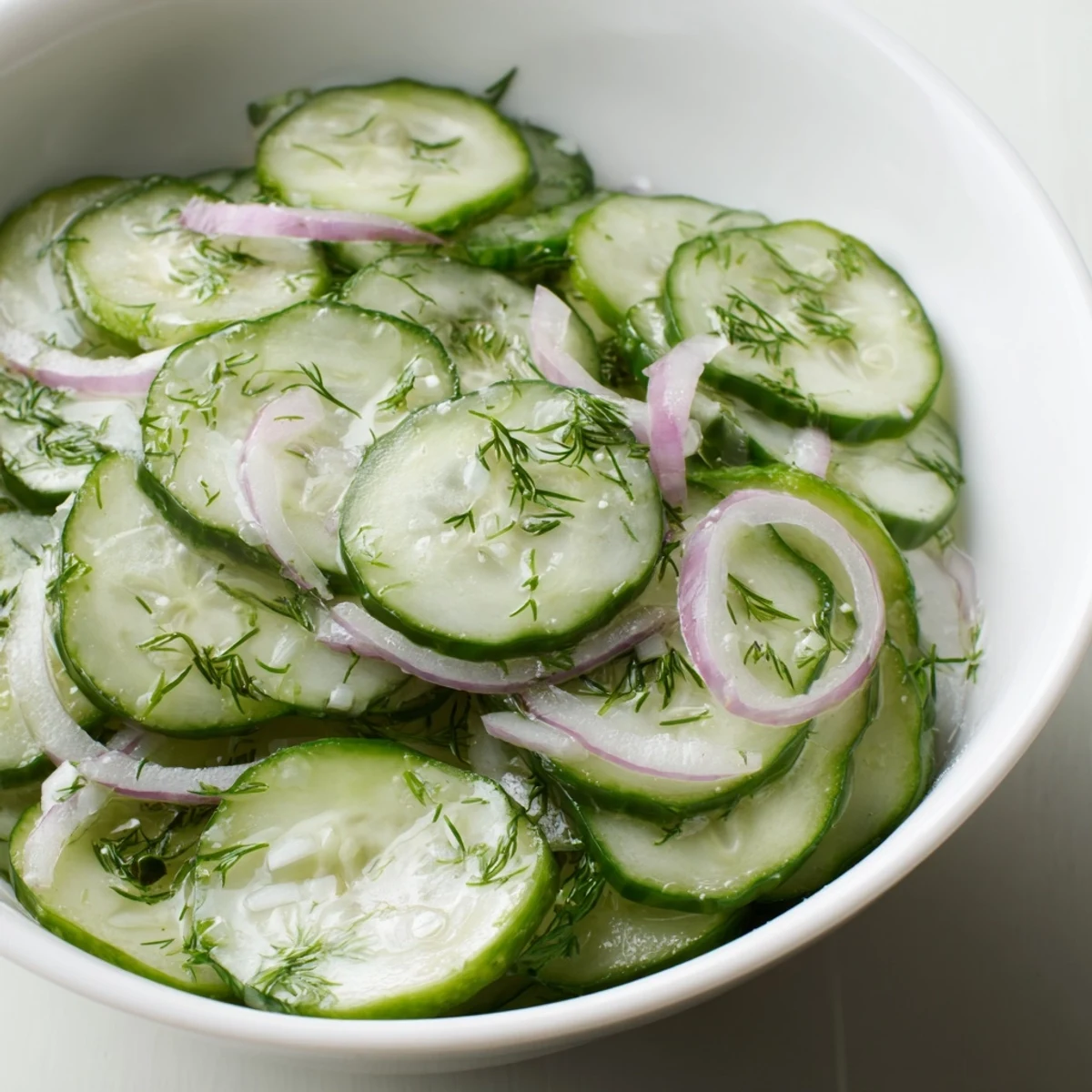 Thinly sliced Cucumber Salad tossed with red onion, crisp and refreshing