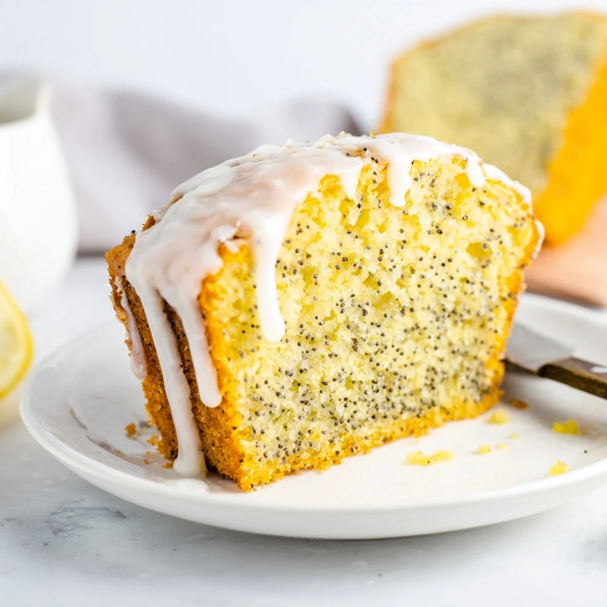 Bright yellow lemon poppy seed cake topped with sweet glaze and served on a rustic wooden board