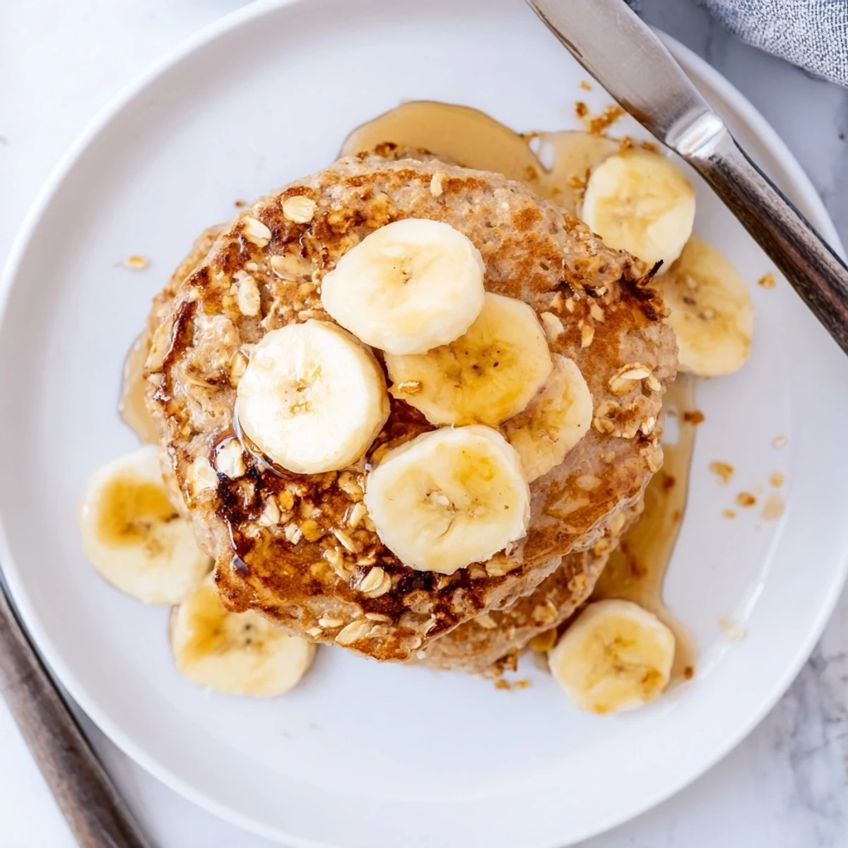 Homemade protein banana pancakes cooking on a skillet with bubbles forming on the surface