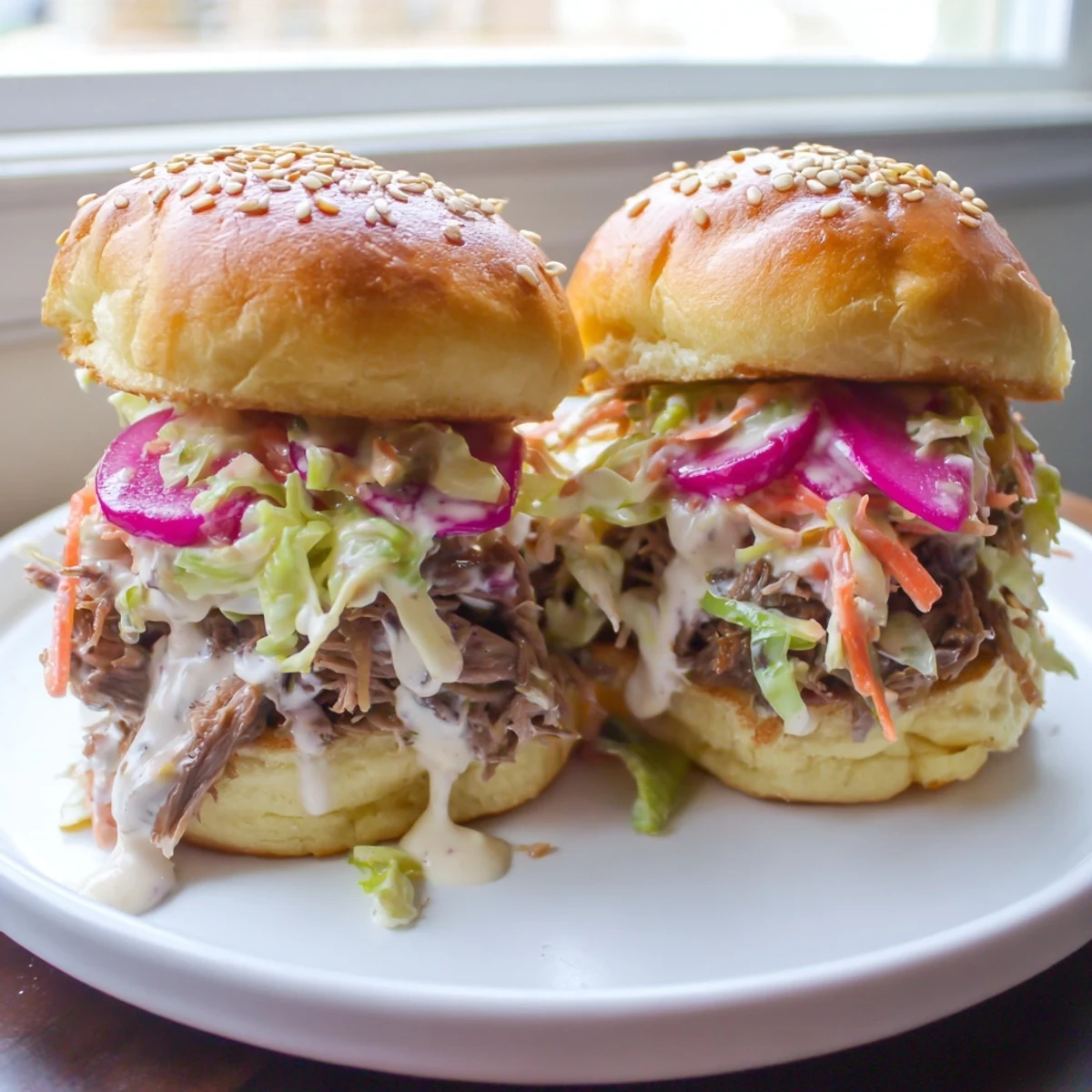 Tangy Alabama white sauce pulled lamb sliders piled high with crunchy vinegar slaw