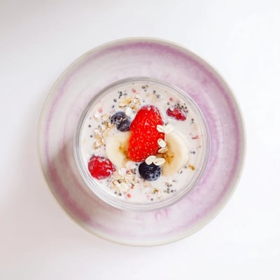 Vibrant purple Greek yogurt breakfast smoothie topped with fresh berries and granola for texture